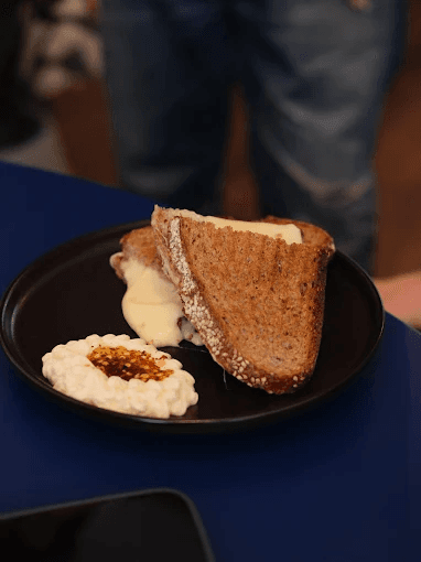 A double grilled cheese on rye with cottage cheese and chilli oil
